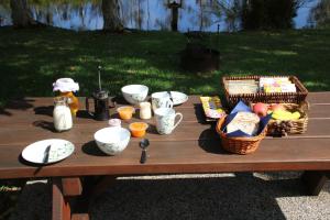 a picnic table with bowls and dishes on it at Salamander Bay Bed and Breakfast in Salamander Bay