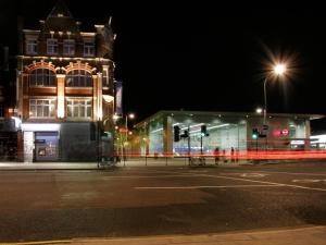 una calle de la ciudad por la noche con un edificio y un semáforo en W12 Rooms, en Londres