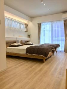 a bedroom with a large bed and a large window at A-Style Futenma in Ginowan