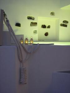 una mostra di musei con corda e rocce sul muro di Irida - Santorini a Imerovigli