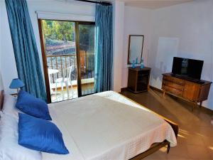 a bedroom with a bed and a television and a balcony at Casa Pepe in Fasnia