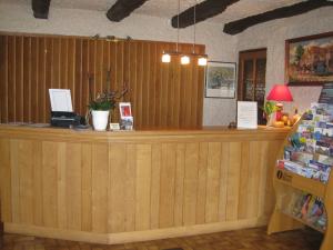 a wooden counter in a store with a cash register at Hôtel Les Pavillons du Golf in Évian-les-Bains