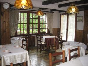 a dining room with tables and chairs and windows at Hôtel Les Pavillons du Golf in Évian-les-Bains