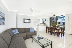 een woonkamer met een bank en een tafel bij Headland Tropicana Resort in Alexandra Headland