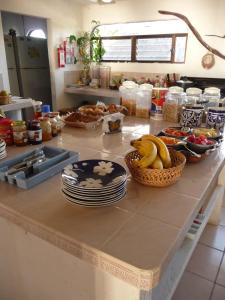 a kitchen counter with plates and bowls of fruit on it at Rancho Sakol in Puerto Morelos