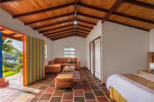 - un salon avec un lit et un canapé dans l'établissement Hotel Zocalo Campestre, à Guatapé