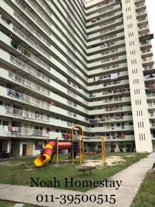 un gran edificio de apartamentos con un parque infantil delante de él en Noah homestay en Kuala Lumpur
