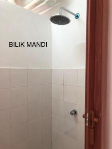 a bathroom with a shower with a sink manual sign on the wall at Noah homestay in Kuala Lumpur