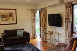 a living room with a couch and a flat screen tv at Australian Home Away @ Wonga Park Brushy Creek in Wonga Park