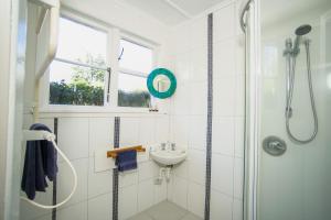 a white bathroom with a sink and a shower at Mahaanui Cottage Farmstay in Tiniroto +18 photos