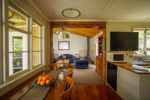 Mahaanui Cottage Farmstay في Tiniroto: مطبخ وغرفة معيشة مع طاولة عليها برتقال