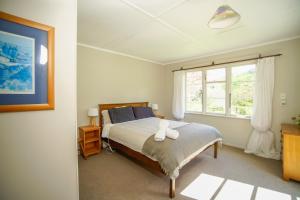 Mahaanui Cottage Farmstay في Tiniroto: غرفة نوم بسرير كبير ونافذة