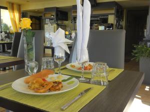 a table with two plates of food and glasses of wine at Hotel Princess in Vernet-les-Bains