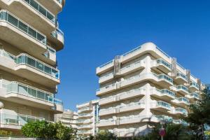 a tall white apartment building with balconies on it at Rentalmar Families Larimar in Salou