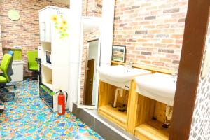 a bathroom with two sinks and a brick wall at Shinjuku Sky hostel in Tokyo