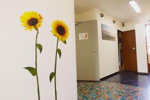 two yellow flowers in a vase in a hallway at Shinjuku Sky hostel in Tokyo +129 photos