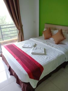巴真府的住宿－綠地汽車旅館，一间卧室设有一张大床和绿色的墙壁