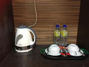 バンティングにあるHappy Stay @ Morib Gold Coastのコーヒーメーカー、テーブルの上にボトル入り飲料水2本