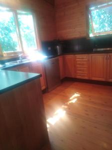 an empty kitchen with wooden floors and windows at Mango Cottage in Horseshoe Bay