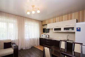 a kitchen with white cabinets and a counter top at Апарт-отель 7 этажей Тюмень Центр in Tyumen