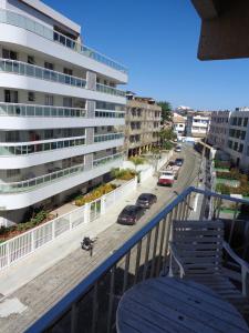 d'un balcon avec une table bleue, des chaises et une rue. dans l'établissement Apartamento praia do forte, à Cabo Frio