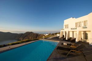 a villa with a swimming pool next to a house at Avaton Resort And Spa in Imerovigli