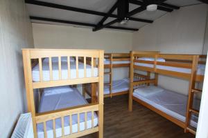 um quarto com três beliches num quarto em The White Horse Inn Bunkhouse em Threlkeld