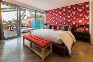 a bedroom with a large bed and a red wall at Hotel Éclat Beijing in Beijing