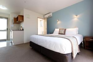 um quarto com uma cama grande e uma cozinha em Riccarton Motor Lodge em Christchurch