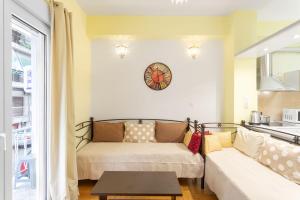 salon z kanapą i zegarem na ścianie w obiekcie Athens Home 2 w Atenach