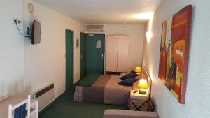 - une chambre avec un lit et une table avec une lampe dans l'établissement Hôtel de Genève et Restaurant , Faverges-Seythenex, à Faverges