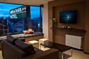 a living room with a couch and a tv at Hotel Aires de Tandil in Tandil