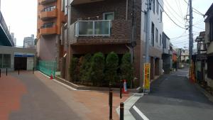a building with a window on the side of a street at Shinjuku Sky hostel in Tokyo