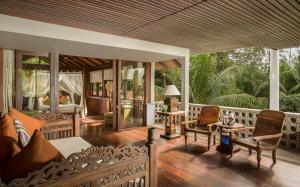 Habitación con porche con sillas y mesas. en Jeeva Saba Bali, en Saba