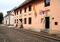 ein Gebäude mit Flaggen auf der Straßenseite in der Unterkunft Altstadthotel Goldene Kugel in Waren (Müritz)