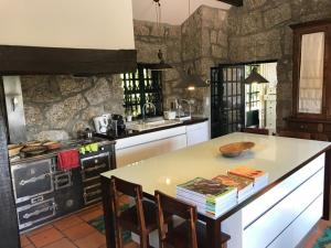 uma cozinha com uma mesa com cadeiras e um fogão em Casa da Cresso em Amares