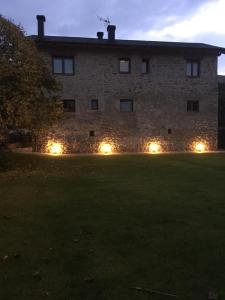 un edificio con luces en un patio por la noche en Cal Pedrals Pairal en Urus