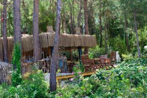 a hut with chairs and tables in the woods at Liberty Lykia Adults Only in Oludeniz