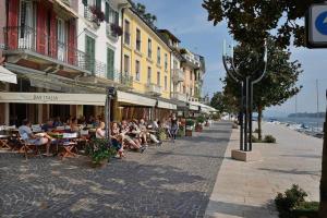 a group of people sitting at tables on a city street at MIRALAGO - Garda Leisure in Salò