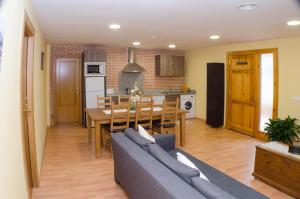 Una sala de estar con un sofá y una mesa y una cocina. en Casa Taragaña, en Beceite