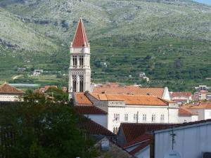 een gebouw met een klokkentoren in een stad met een berg bij Apartments Kairos in Trogir