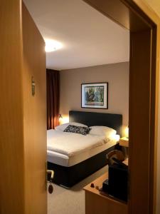 um quarto de hotel com uma cama e um espelho em Hotel Restaurant Denis em Zemmer