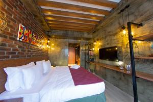Meydan Besiktas Hotel في إسطنبول: غرفة نوم بسرير وجدار من الطوب