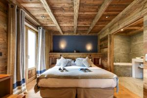 a bedroom with a large bed with wooden ceilings at Au Coin Du Feu in Megève