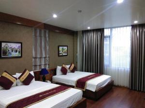A bed or beds in a room at Golden Thai binh Hotel
