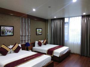 a hotel room with two beds and a window at Golden Thai binh Hotel in Thái Bình +69 photos