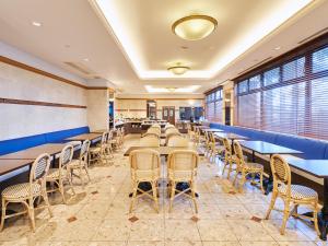 a row of tables and chairs in a restaurant at HOTEL MYSTAYS Maihama in Urayasu