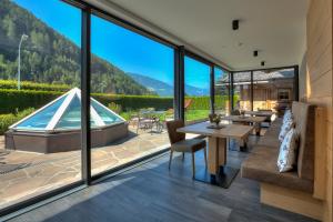 a living room with a view of a pool and mountains at Hotel Residence Rose in Vipiteno