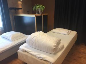 2 camas con almohadas blancas en una habitación en Malmköpings Bad & Camping, en Malmköping