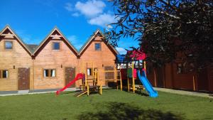 a playground with play equipment in front of a building at Domki Kaja in Rewal